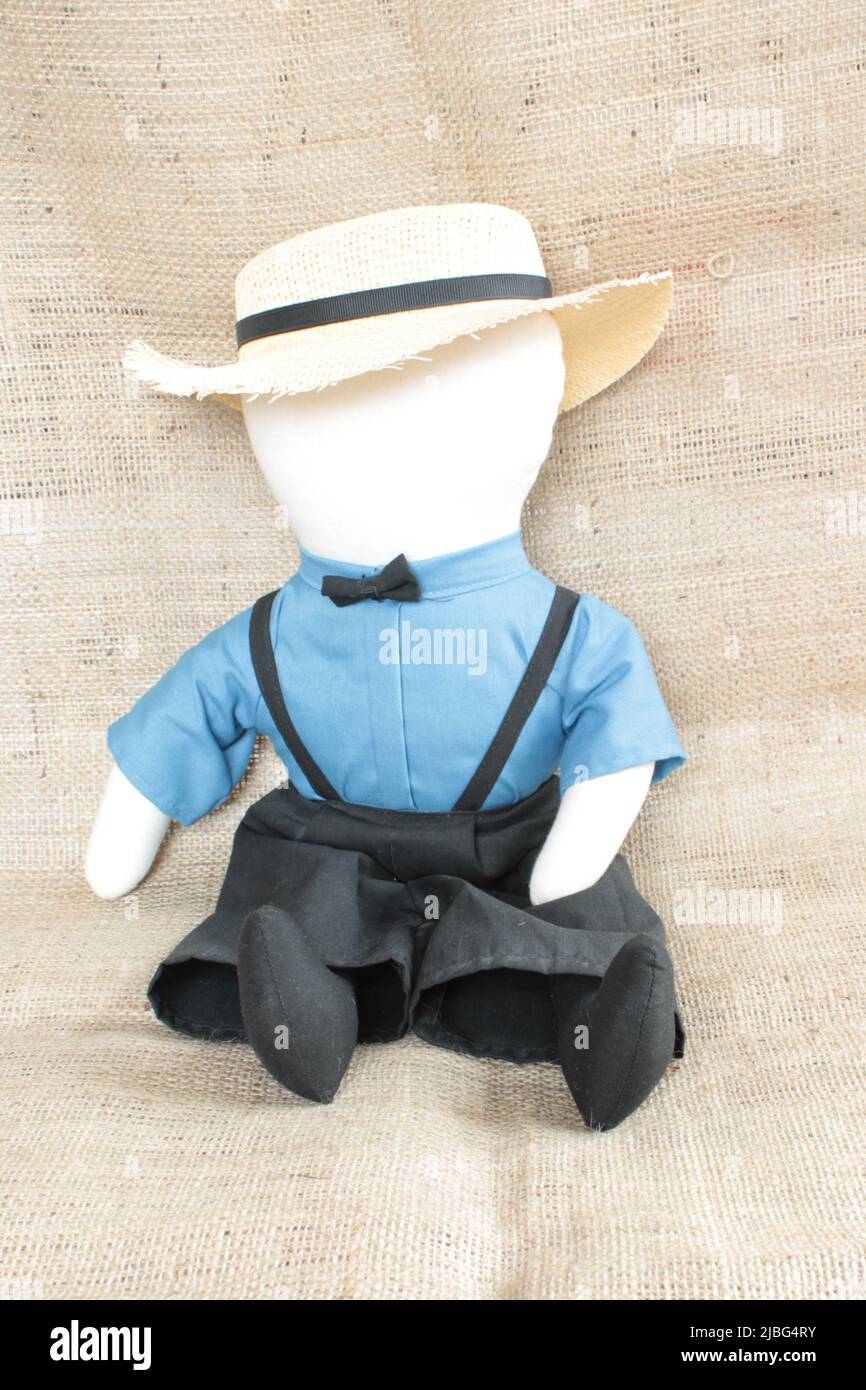 Bambola Amish, bambola Amish maschio senza volto tradizionale in abiti tradizionali su sfondo hessiano con spazio copia Foto Stock