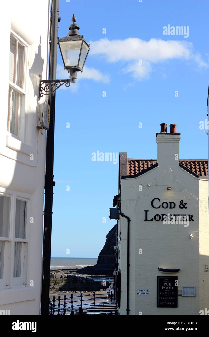 Vista sul mare a Staithes, un pittoresco villaggio di pescatori dello Yorkshire. Il merluzzo e l'aragosta sono popolari tra i visitatori per i suoi pesci e patatine Foto Stock