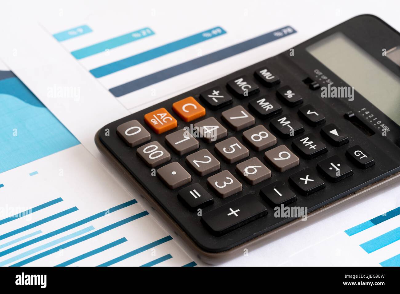 Primo piano di foto di pila di monete e grafici e statistiche con calcolatore. Concetto di contabilità, budget e profitto. Foto Stock
