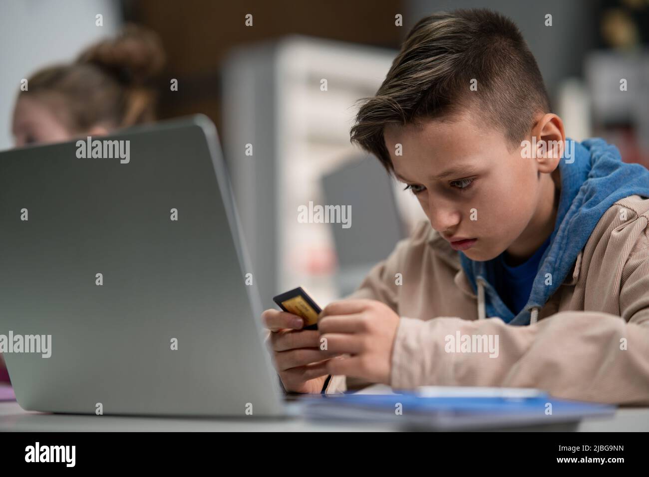 Scolaro che usa il computer in classe a scuola Foto Stock