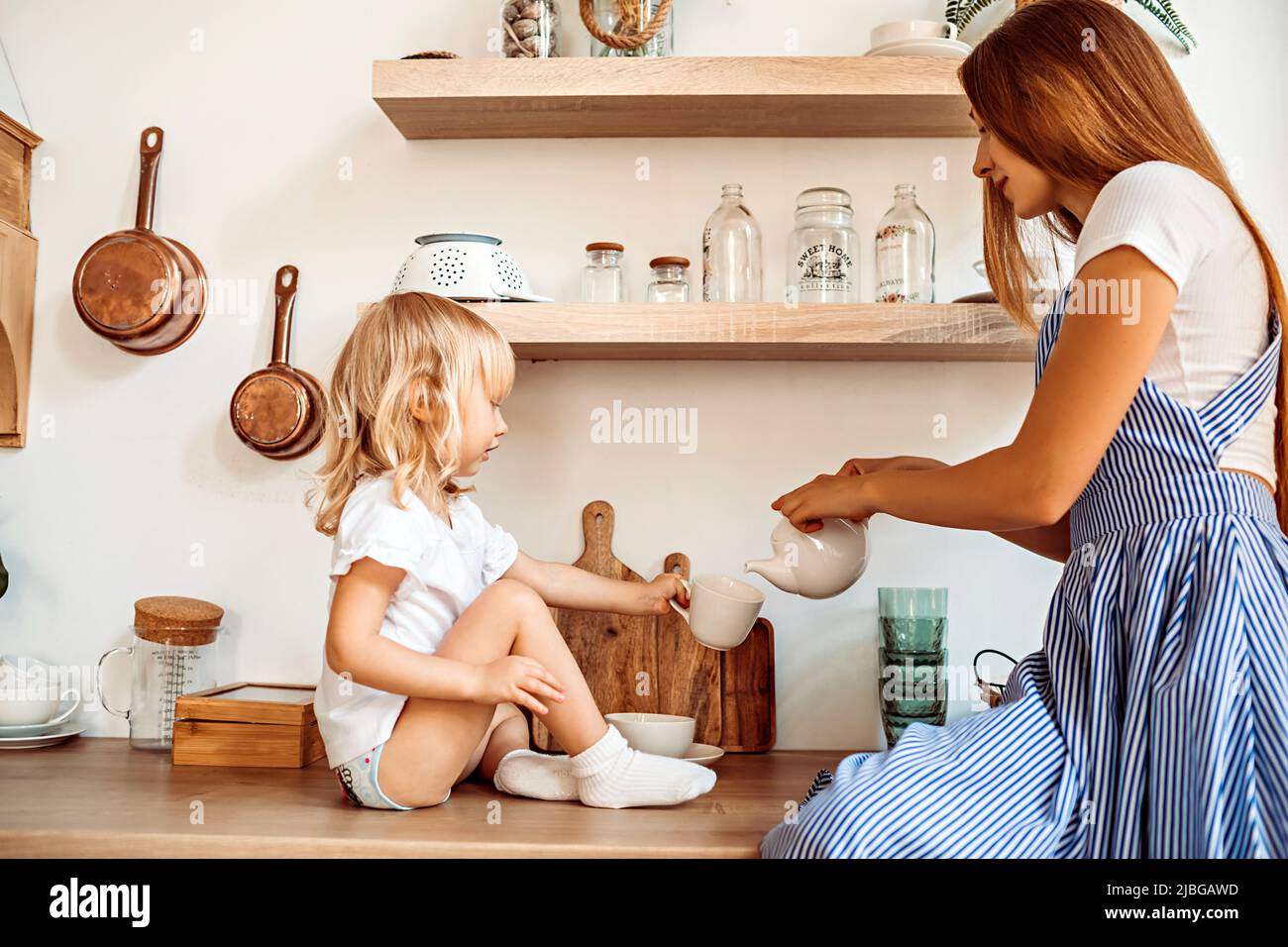 Mamma e bambina si divertono in cucina a casa Foto Stock