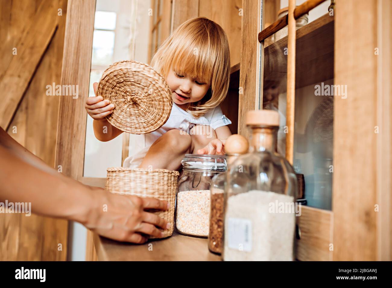 La bambina aiuta la mamma in cucina con le faccende domestiche Foto Stock