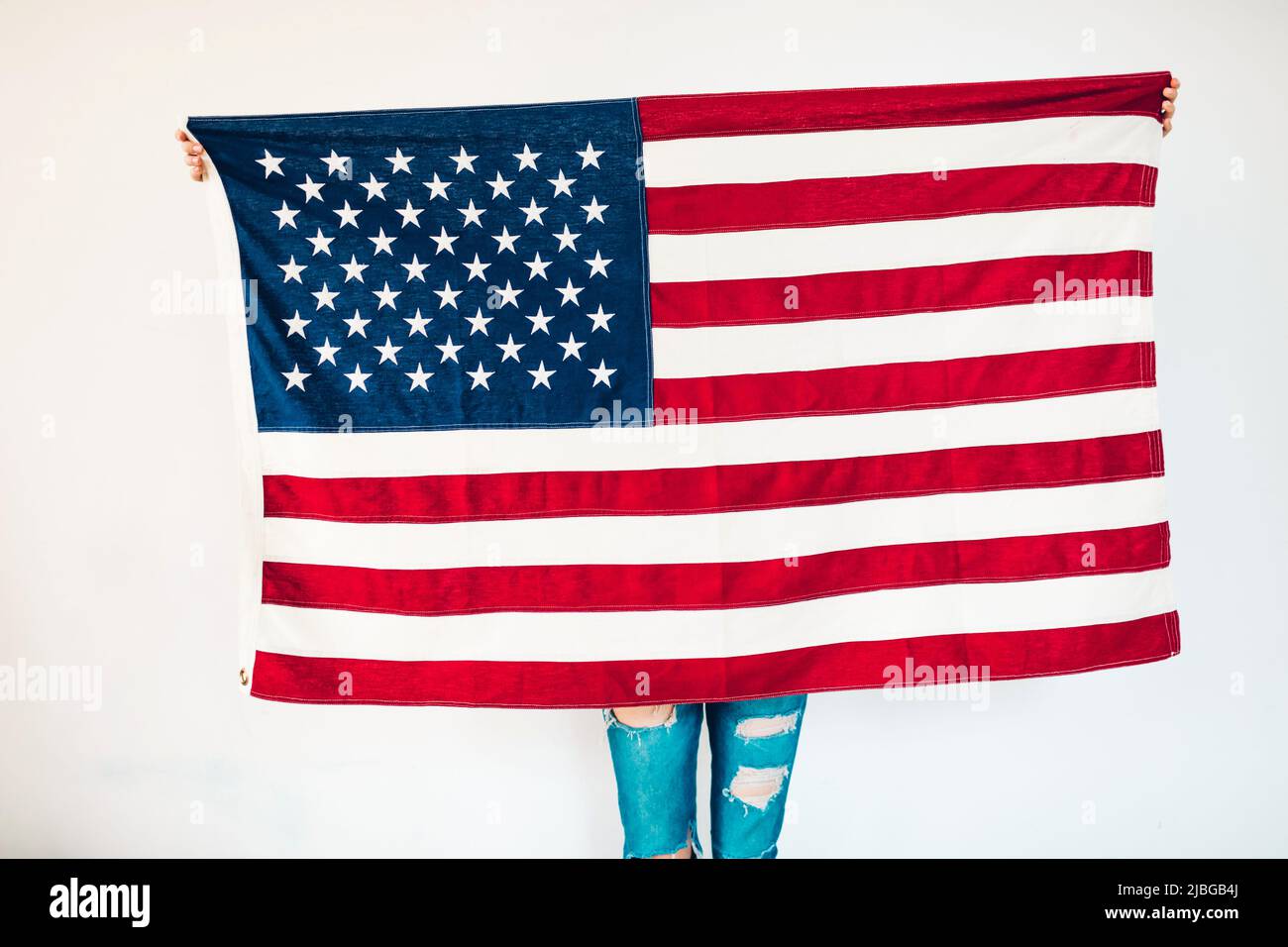 Ragazza che detiene una bandiera americana nel giorno dell'indipendenza degli Stati Uniti, luglio 4th. Concentrarsi sulla bandiera Foto Stock