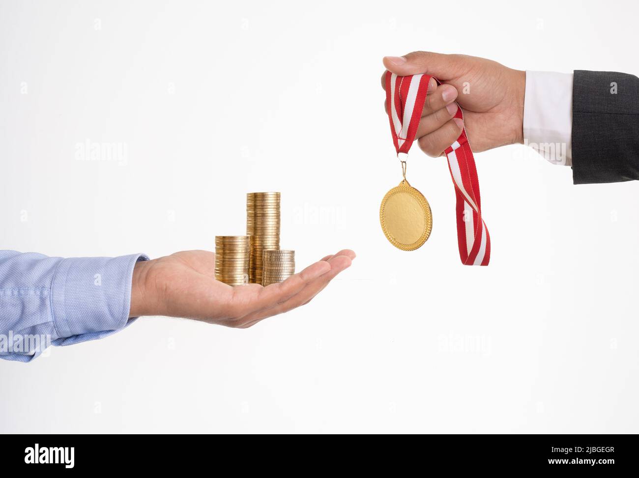 Primo piano foto di mani scambiando denaro e medaglia d'oro su sfondo isolato. Concetto di corruzione. Foto Stock