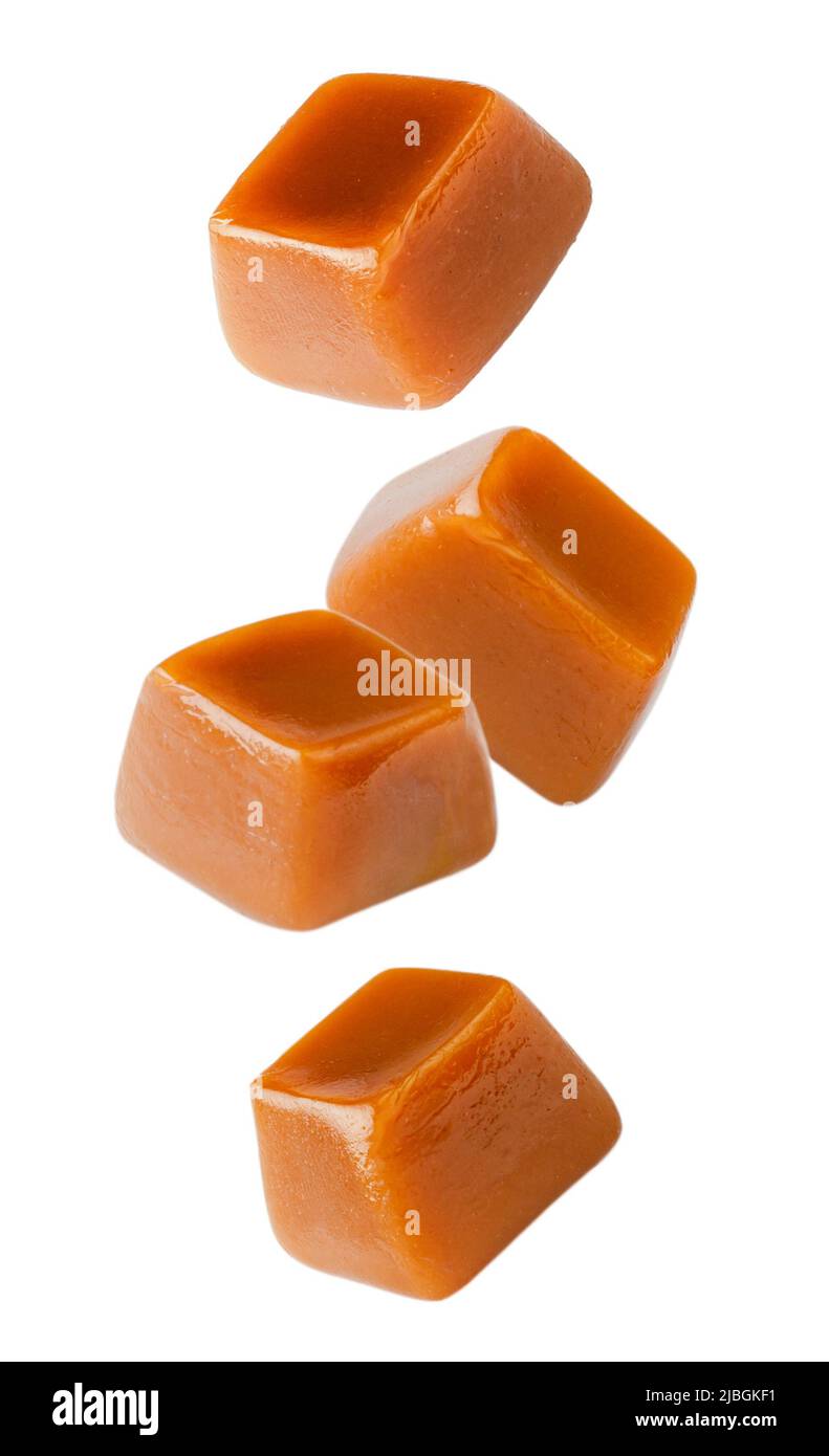 Cubi di caramello volante isolati su sfondo bianco. Set di caramelle al caramello. Foto Stock