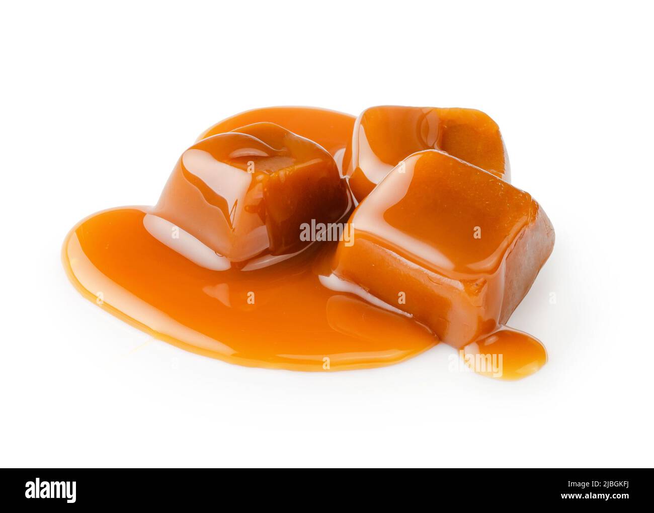 Cubetti di caramello con salsa di caramello isolato su sfondo bianco. Foto Stock