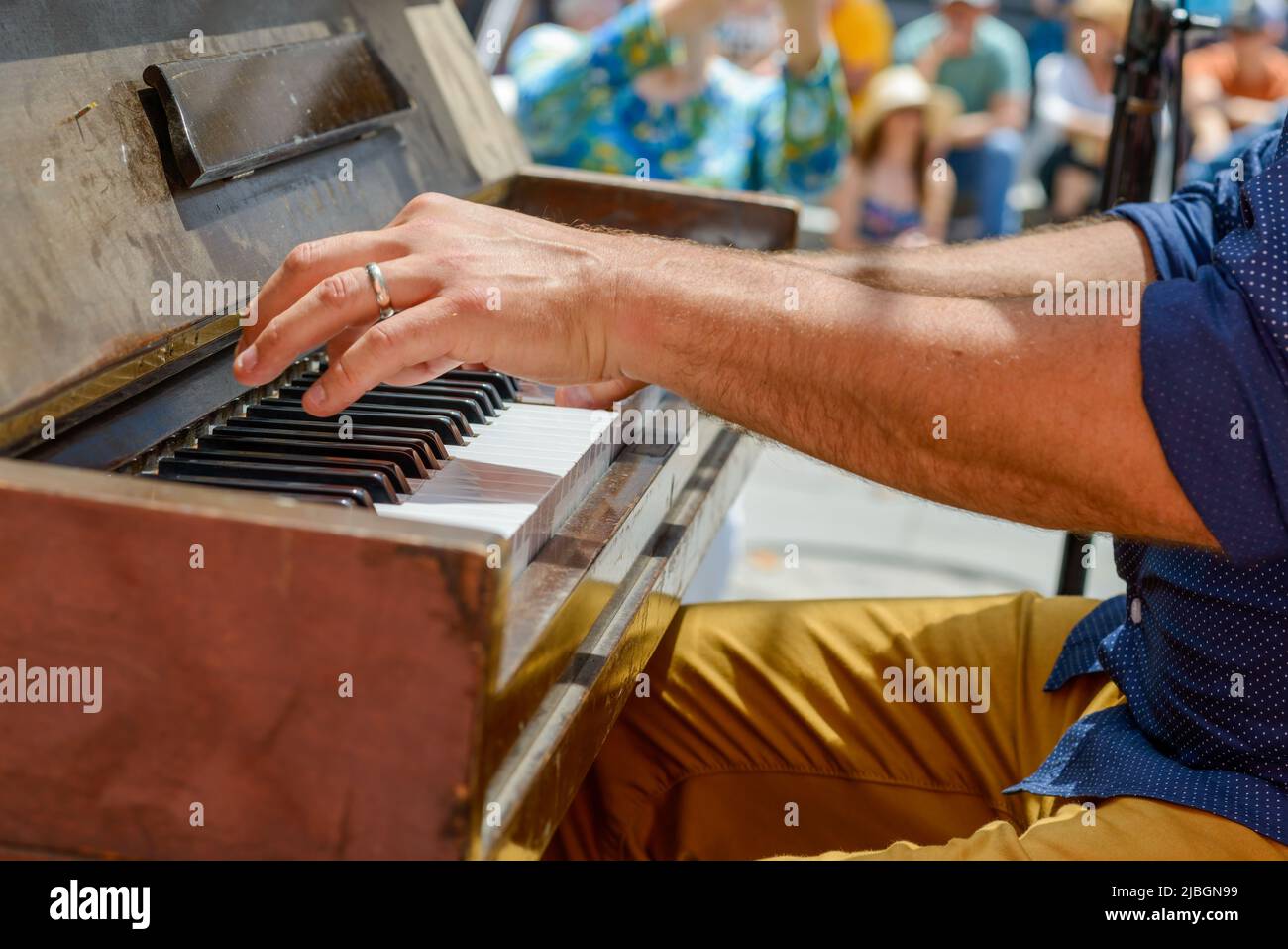 Le mani e i tasti del pianista mentre suona il pianoforte con la folla sfocata sullo sfondo al Festival del quartiere Francese di New Orleans, LA, USA Foto Stock