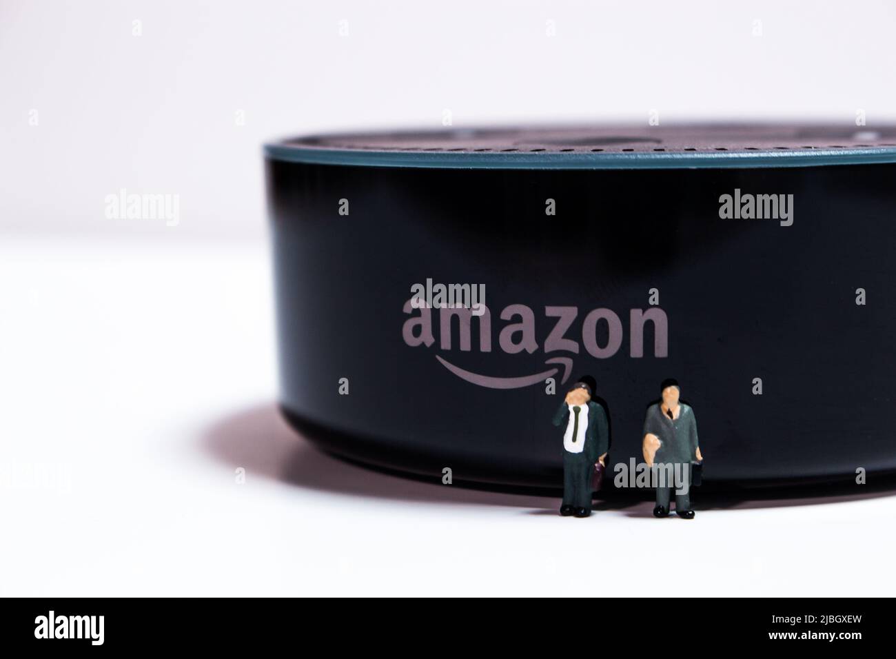 Uomini d'affari in miniatura in piedi di fronte ad Amazon Echo Dot. Amazon Echo (noto anche come Alexa) è un marchio di altoparlanti intelligenti di Amazon Foto Stock