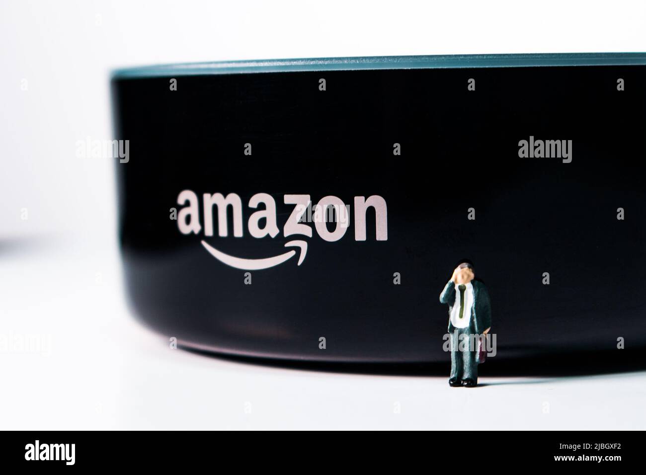 Uomini d'affari in miniatura in piedi di fronte ad Amazon Echo Dot. Amazon Echo (noto anche come Alexa) è un marchio di altoparlanti intelligenti di Amazon Foto Stock