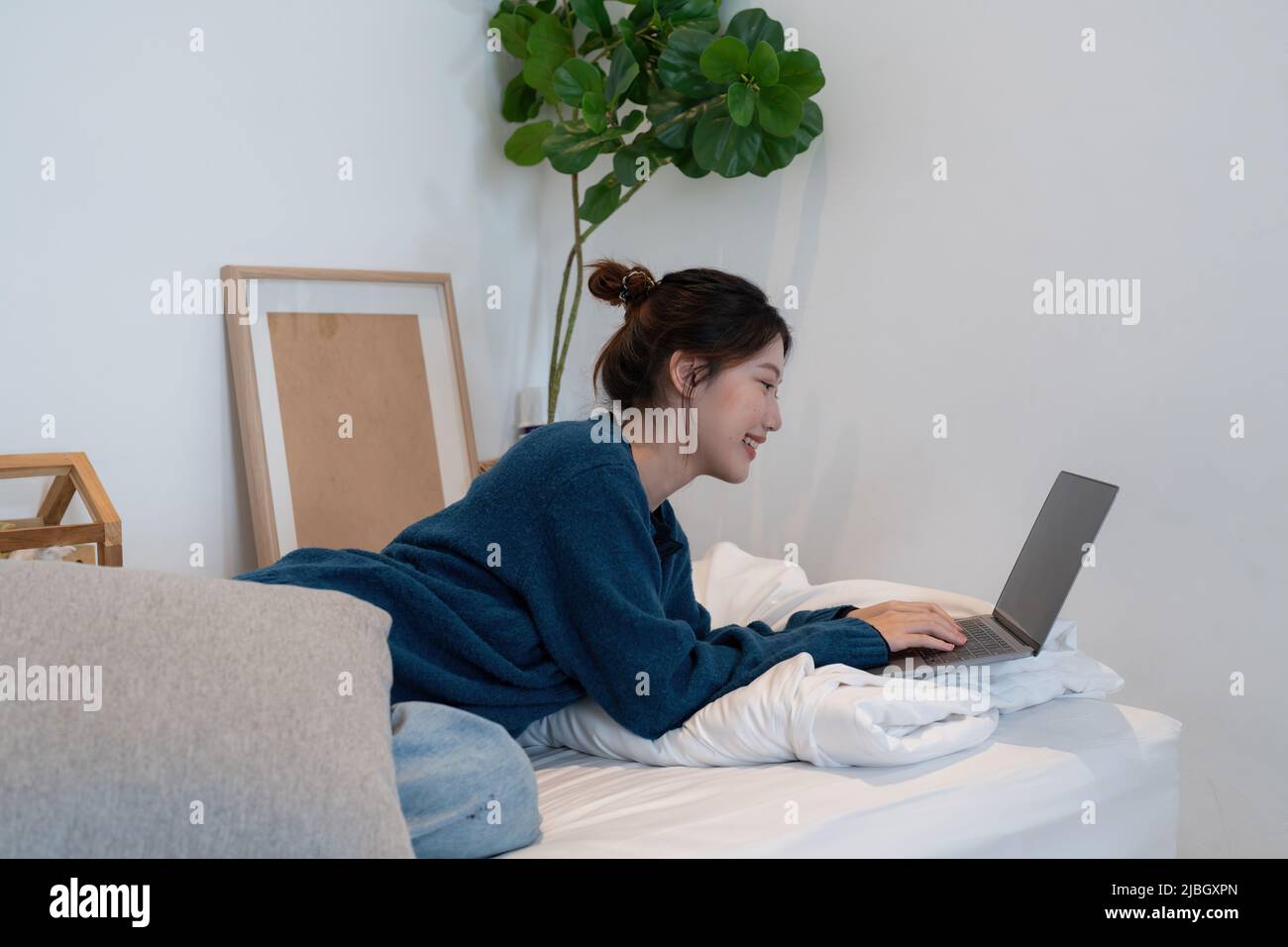 Giovane donna asiatica che parla mentre usa il laptop a casa. Lavoro a casa, videoconferenza, videochiamata online per riunioni, virtuale Foto Stock