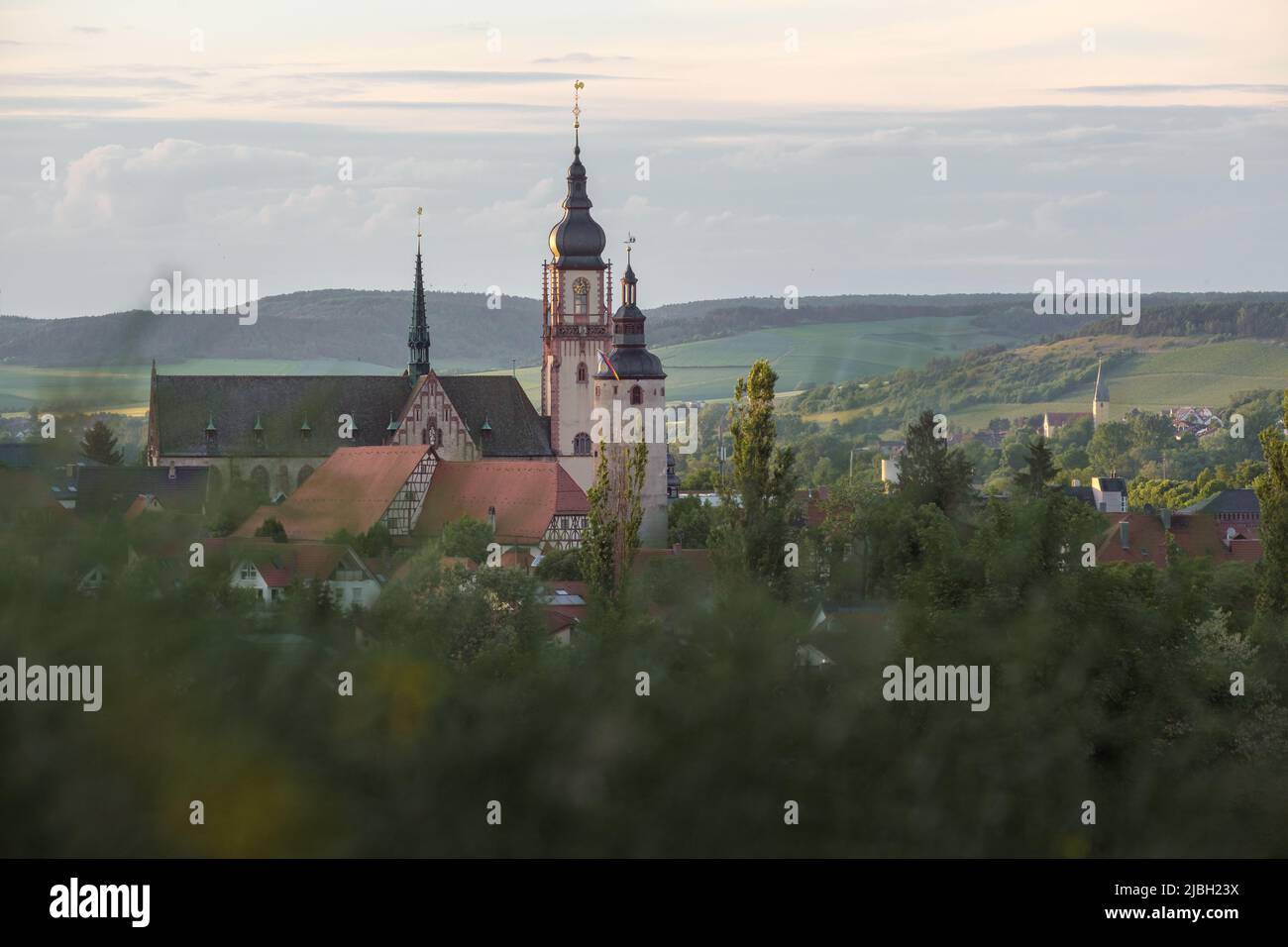 Vista della città tedesca Tauberbischofsheim al tramonto con la chiesa e la torre nel centro della città. Foto Stock
