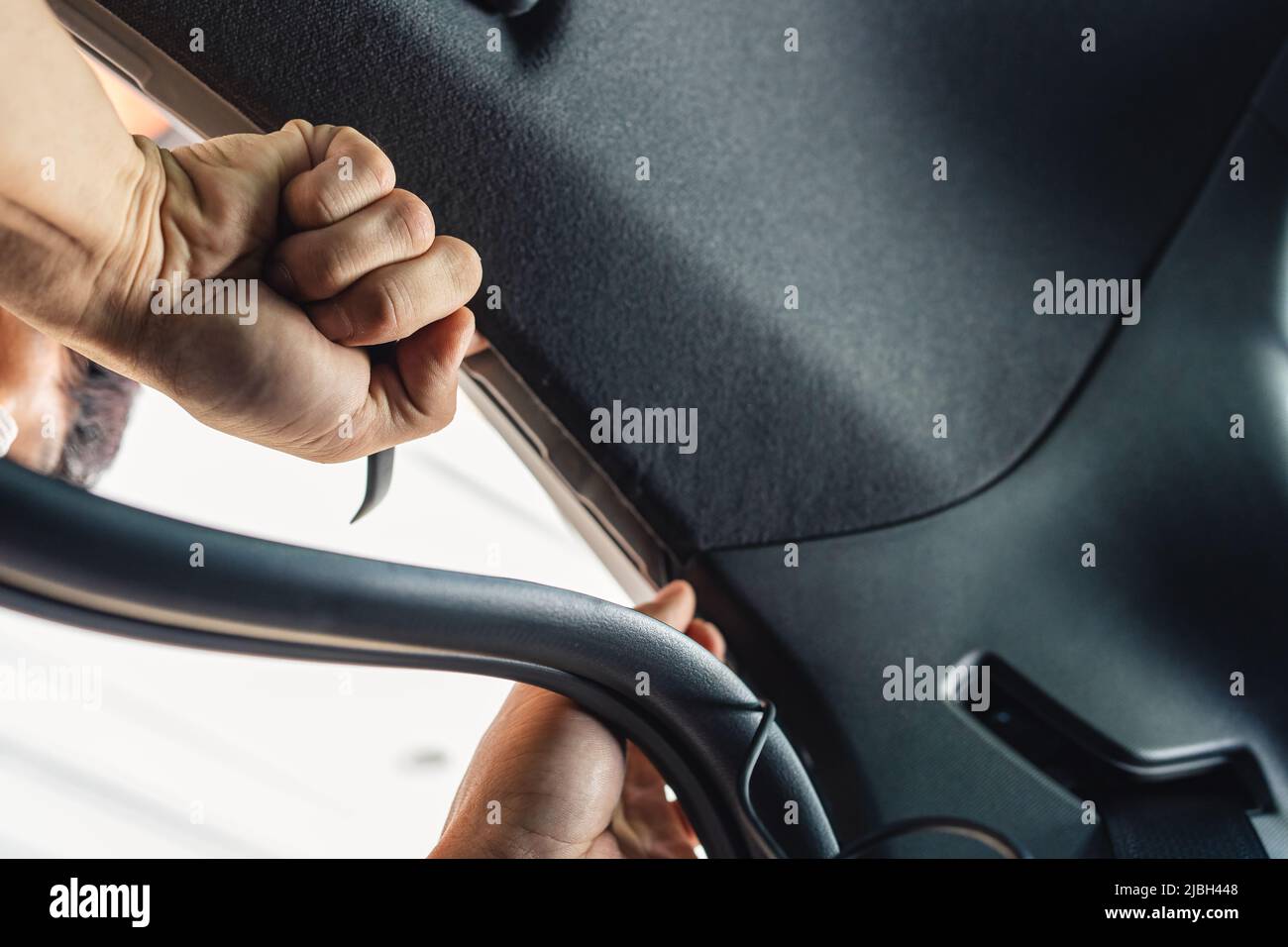 Mano del meccanico utilizzando un cuneo rimuovendo e installando una camma del cruscotto all'interno di un'automobile all'officina del garage Foto Stock