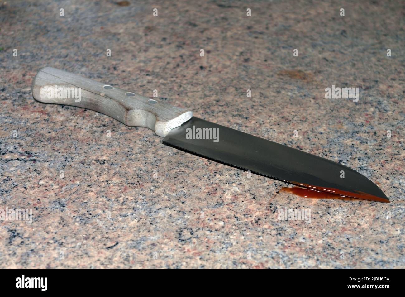 Immagine simbolica: Coltello con manico in legno e sangue sul tagliente Foto Stock