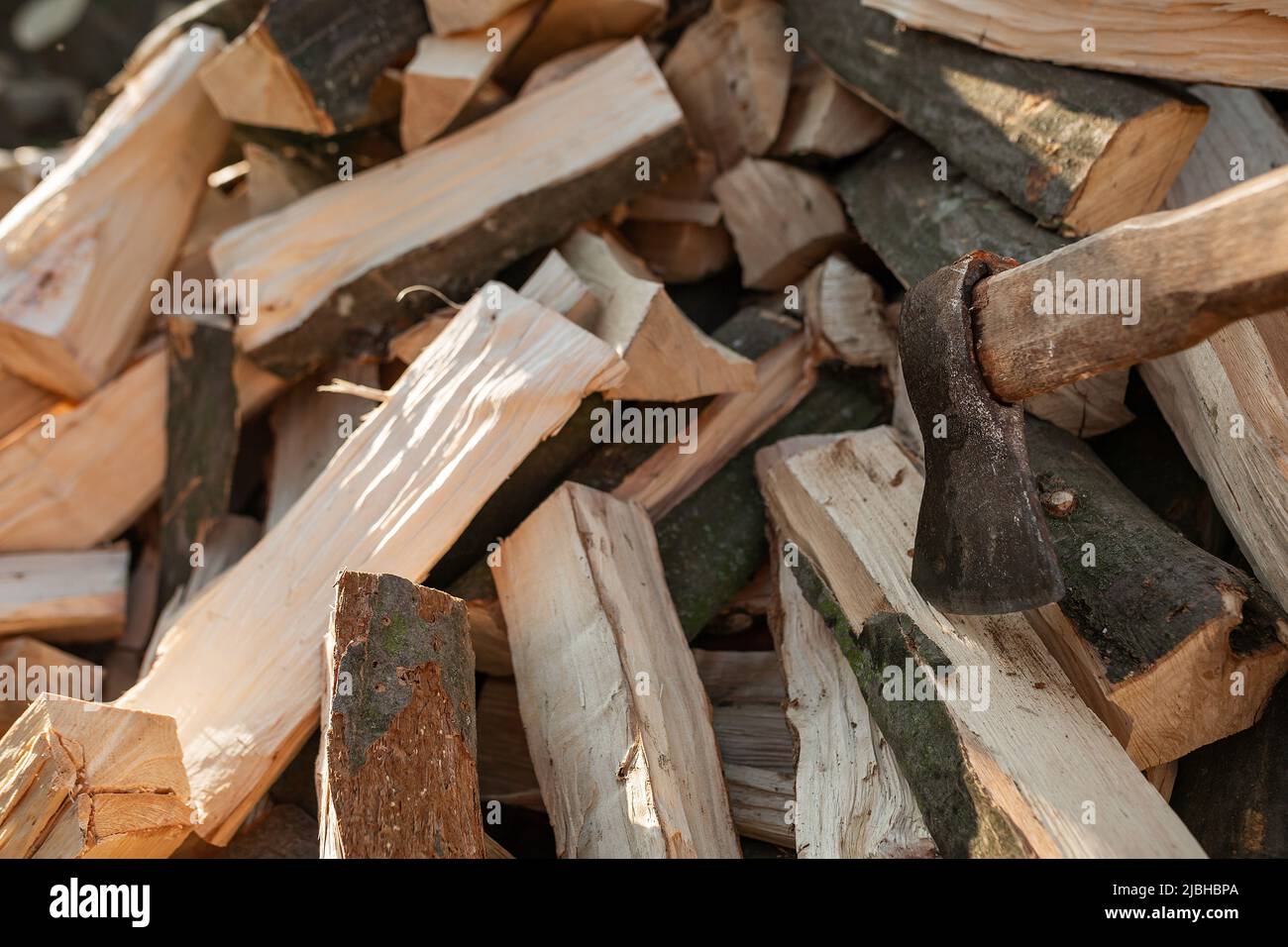 L'ascia si stacca in un ceppo su un mucchio di legna da ardere per la stufa. Agricoltura Foto Stock