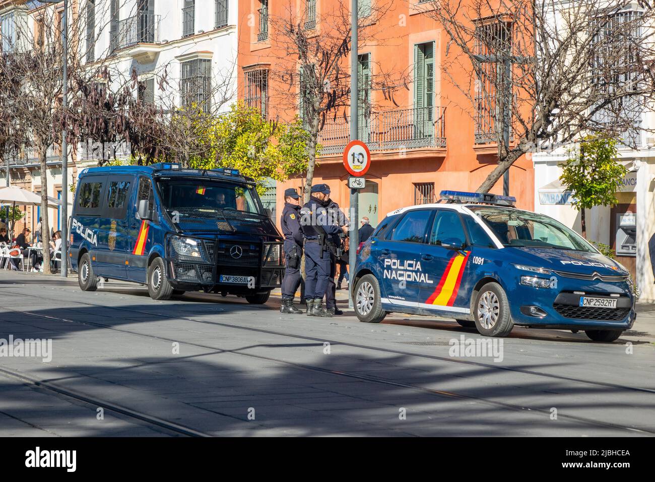 Corpo di polizia nazionale spagnolo (CNP), agenti in piedi tra Un'auto di polizia e un furgone della polizia nel centro di Siviglia Spagna, Policia Nacional Spagna Foto Stock