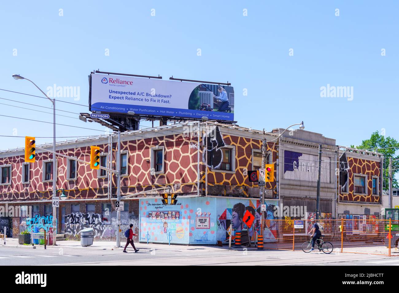 Un cartello Reliance sulla sommità di un edificio con diverse opere d'arte nella facciata. Foto Stock