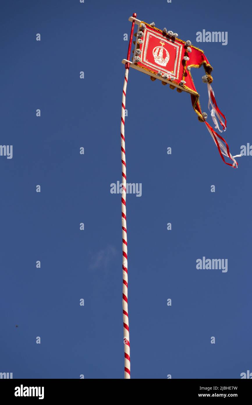 Pirenópolis, Goiás, Brasile – 05 giugno 2022: Una bandiera con la corona del Divino Padre Eterno ricamata su un palo, con bandiere intorno ad esso. Foto Stock