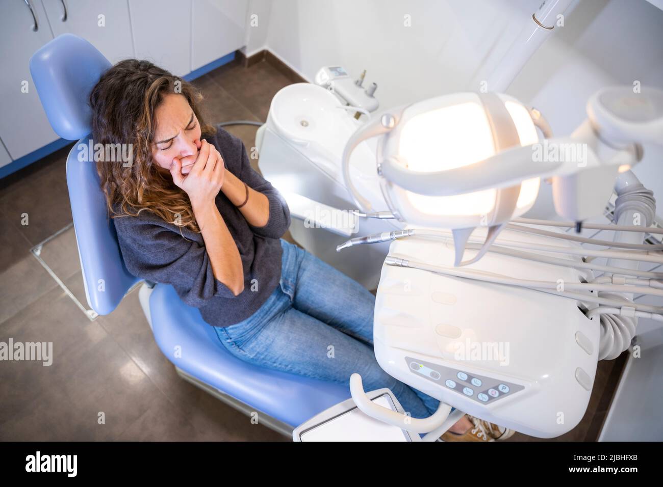 La giovane paziente femmina ha paura alla clinica dentale Foto Stock