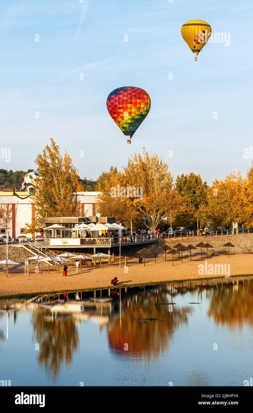 Coruche, Portogallo - 13 novembre 2021: Vista sulla spiaggia fluviale di Coruche in Portogallo, con mongolfiere in volo durante il Festival del Ballooning. Foto Stock
