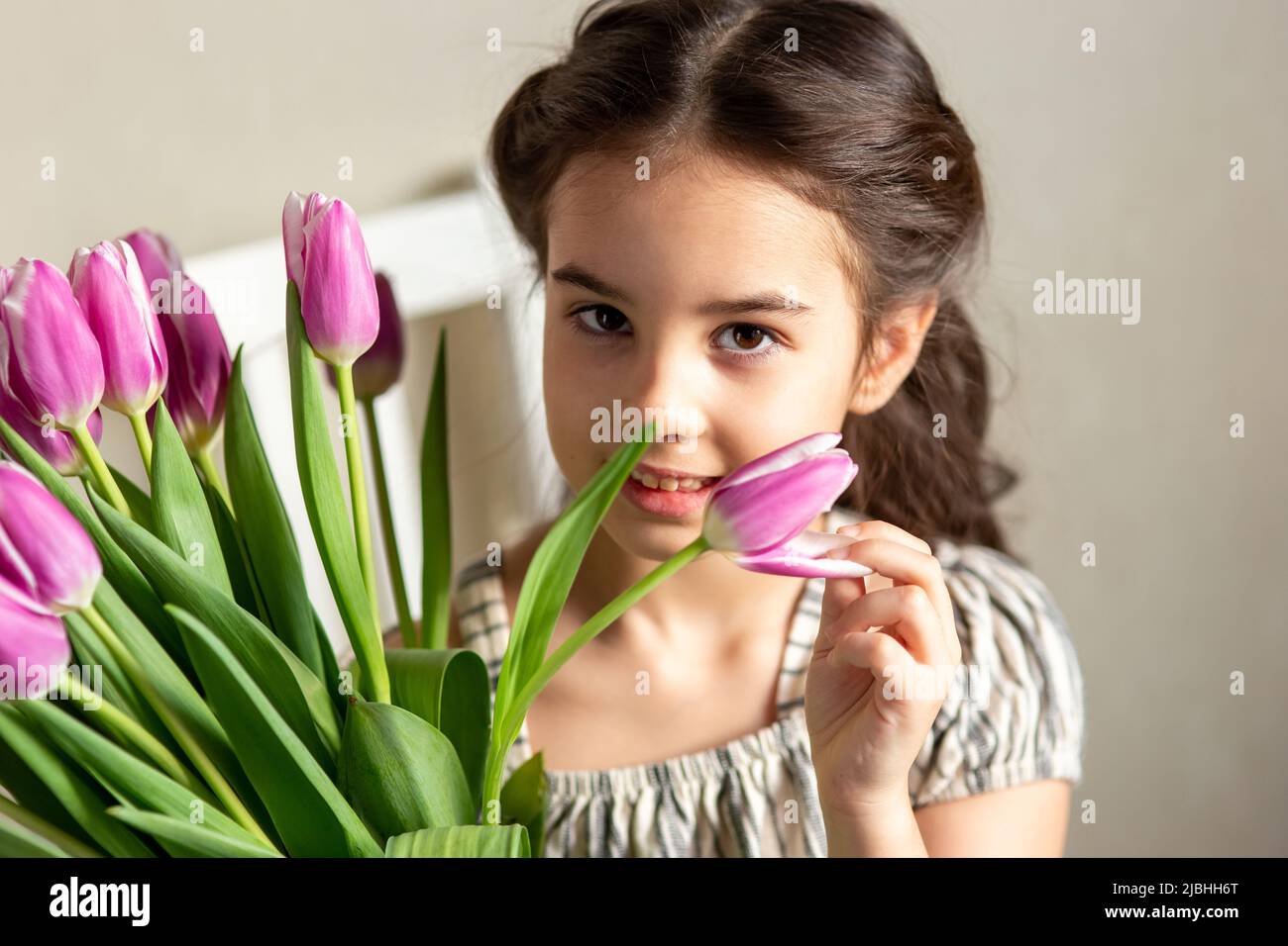 Ritratto di una bella ragazza romantica con un bouquet di tulipani viola Foto Stock