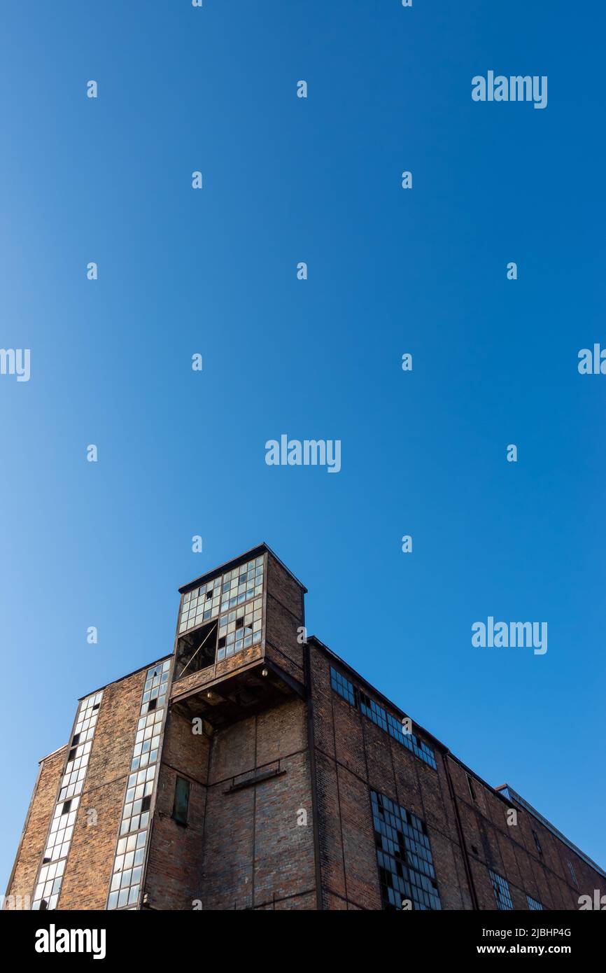 Rovine di un impianto industriale abbandonato. Pareti di mattoni sullo sfondo del cielo blu. Foto scattata in una giornata di sole. Foto Stock