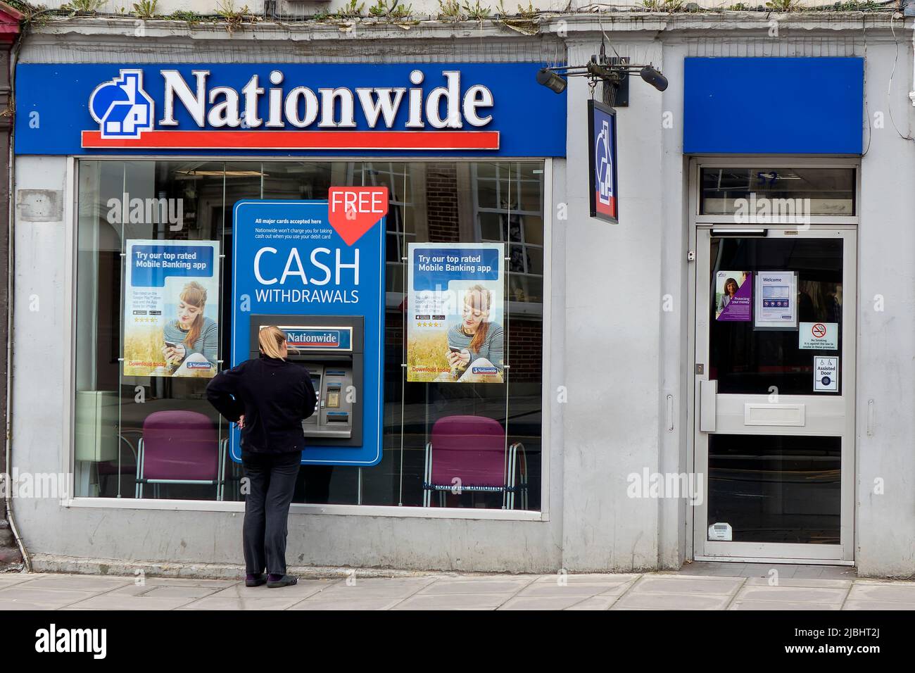 Warminster, Wiltshire, Regno Unito - Ottobre 12 2014:Una donna ritira denaro da un bancomat presso la Nationwide Building Society di Warminster, Wiltshire, Inghilterra, Regno Unito Foto Stock