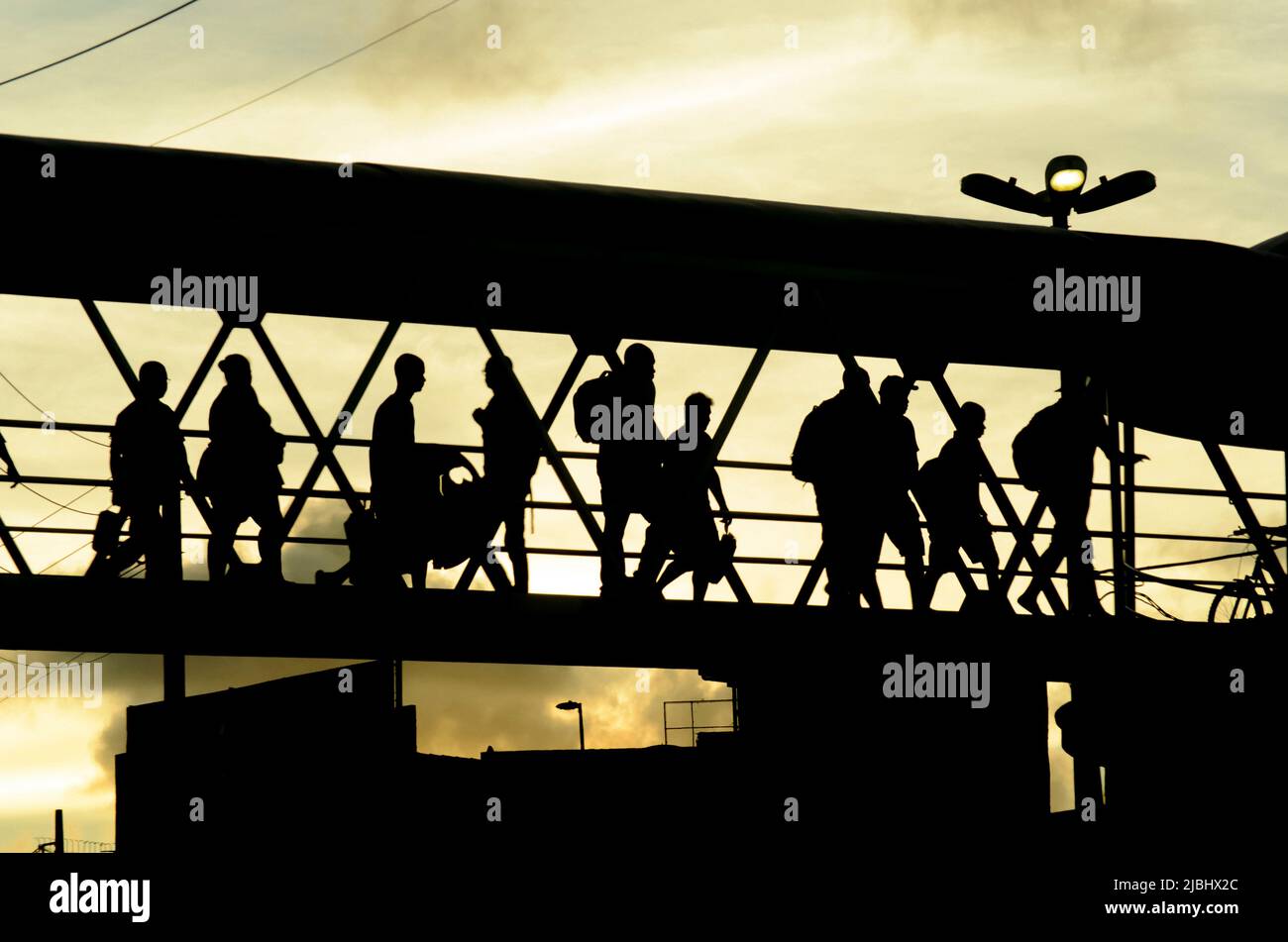 Salvador, Bahia, Brasile - 26 gennaio 2015: Pedoni in silhouette camminando sulla passerella contro il tramonto nella città di Salvador, capitale di Bahia, Brasile. Foto Stock