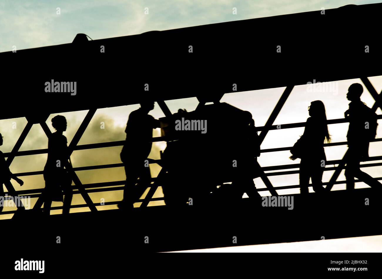 Salvador, Bahia, Brasile - 26 gennaio 2015: Pedoni in silhouette camminando sulla passerella contro il tramonto nella città di Salvador, capitale di Bahia, Brasile. Foto Stock