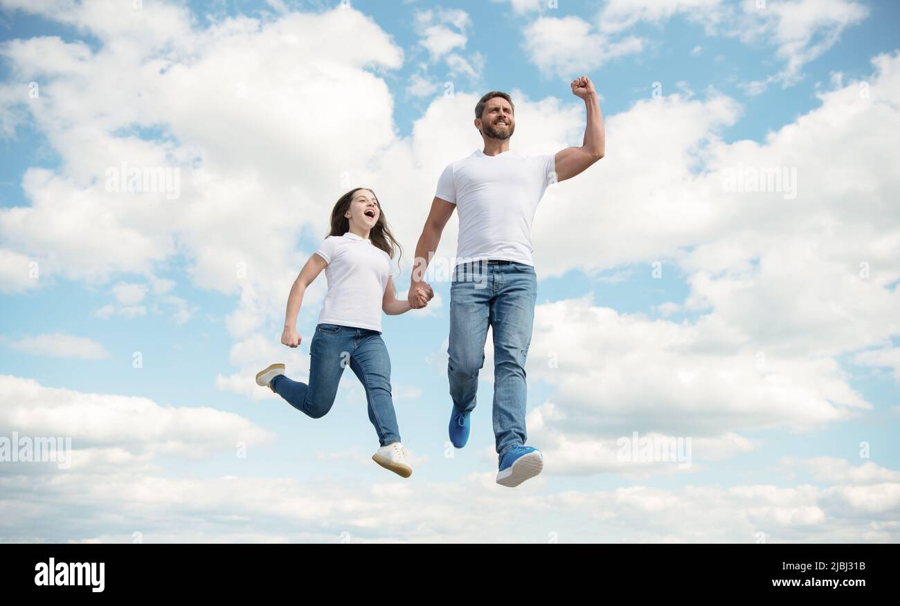 felice padre e figlia saltano nel cielo. felice infanzia Foto Stock