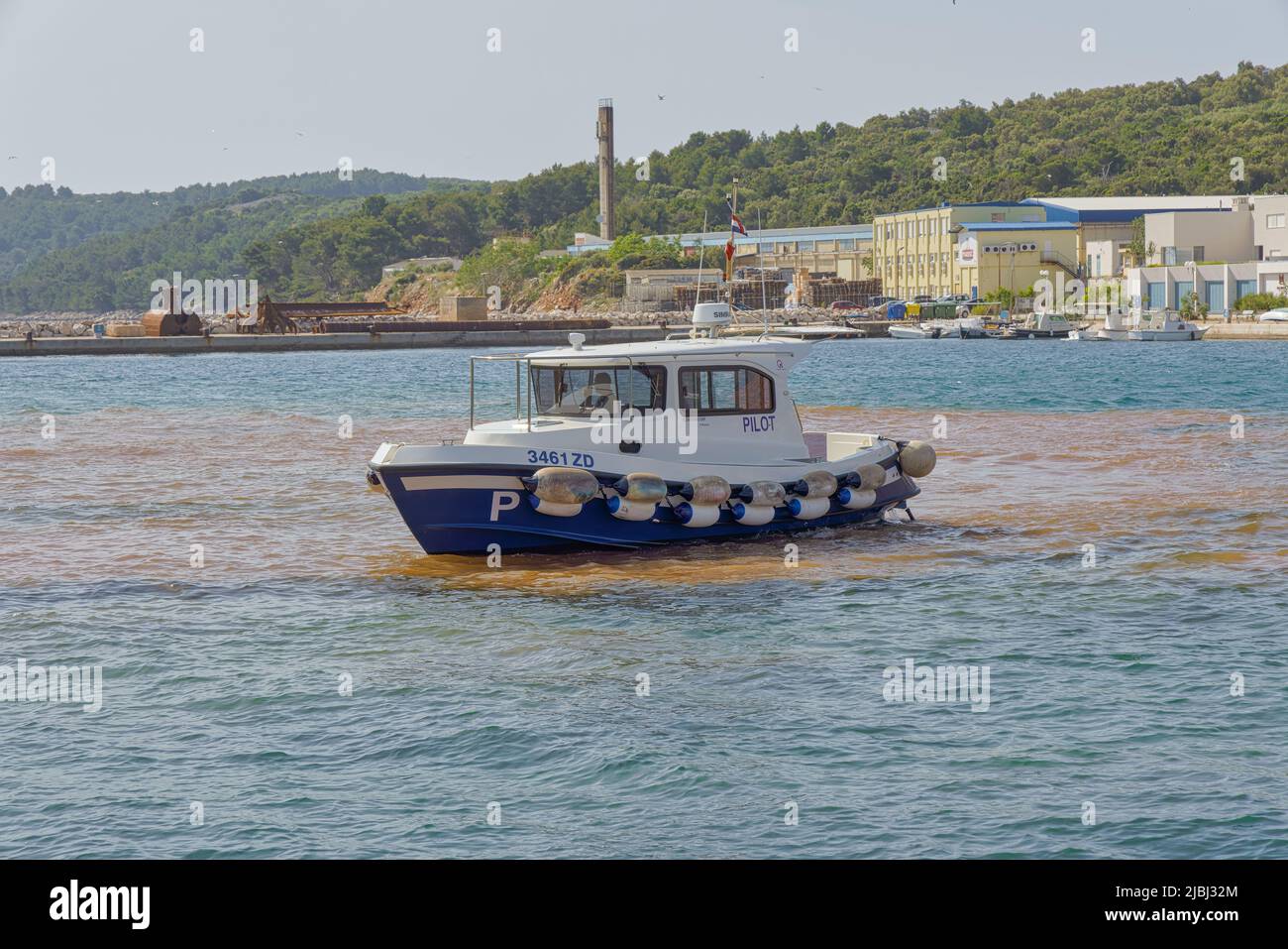 La barca pilota supervisiona le attività di costruzione nella città vecchia di sali, Croazia Foto Stock
