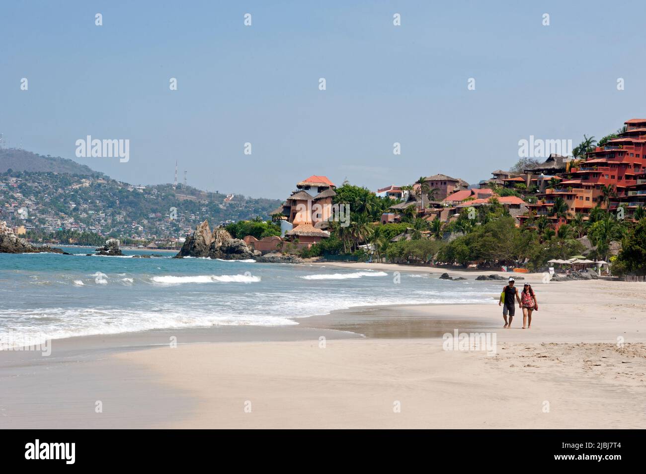Coppia passeggiando sulla spiaggia di Playa Ropa a Zihuatanejo, Messico Foto Stock