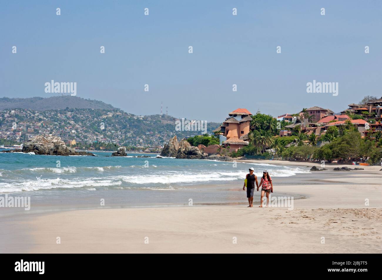 Coppia passeggiando sulla spiaggia Playa la Ropa a Zihuatanejo, Messico Foto Stock