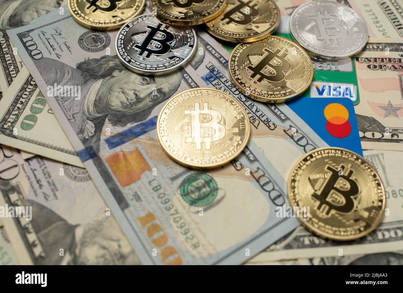 Manhattan, New York/USA - Marzo 26. 2021: Bitcoin su banconote in dollari e carta di credito Visa accanto alla carta di debito Mastercard. Valuta Crypto con plastica Foto Stock