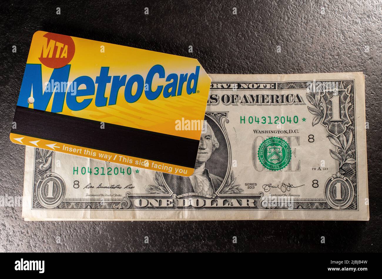 Manhattan, New York/USA - Marzo 26. 2021: Metrocard sopra una banconota da un dollaro. Acquisto di un biglietto per la metropolitana a New York Foto Stock