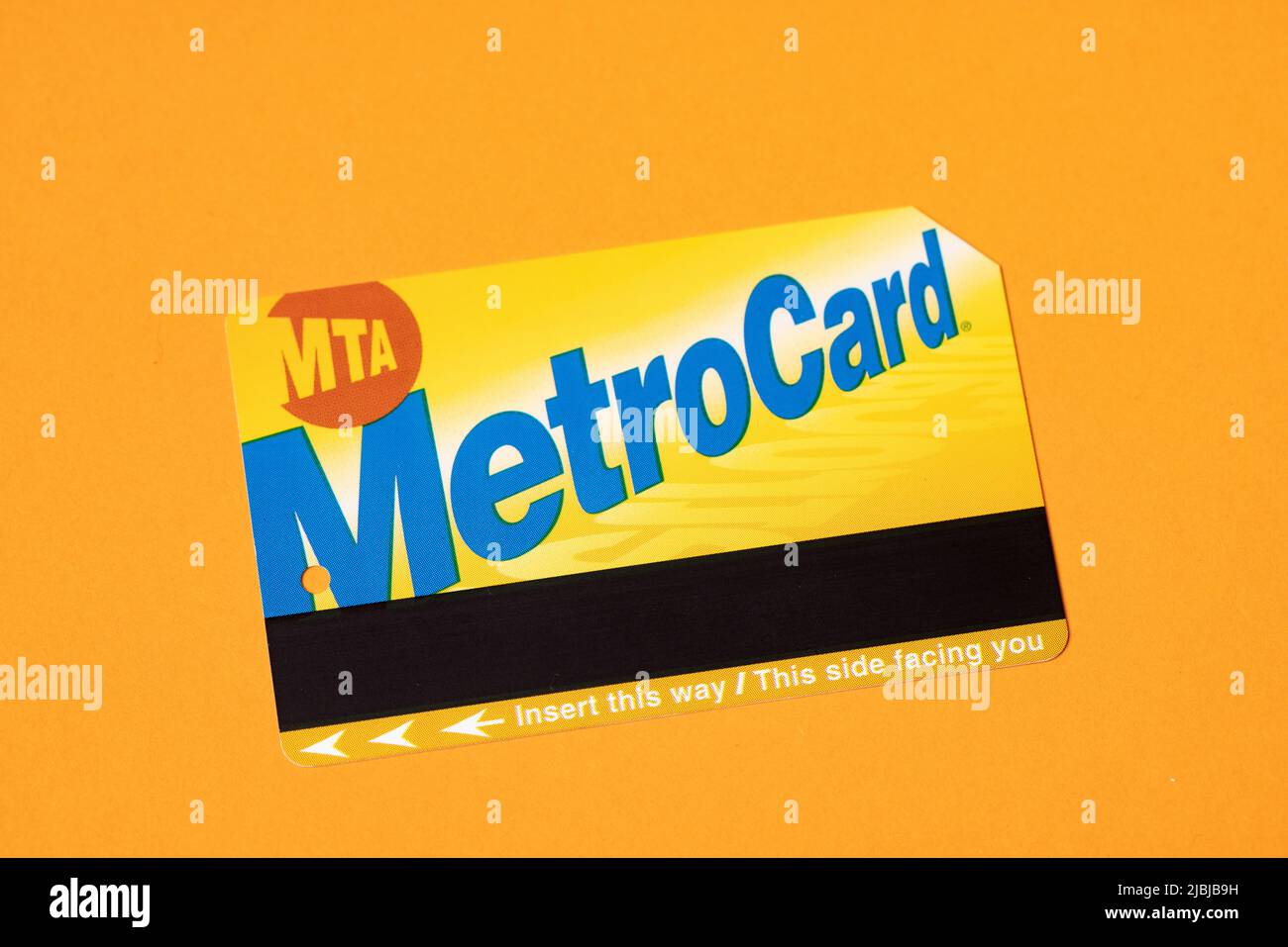 Manhattan, New York/USA - Aprile 8. 2021: New York City Metrocard su sfondo arancione. Biglietto per i mezzi pubblici a New York Foto Stock