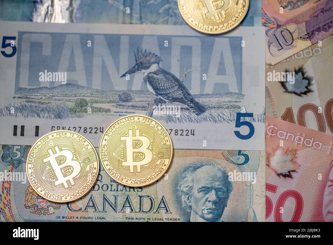 Toronto, Canada - Ottobre 30. 2021: Monete in Bitcoin sulle banconote in dollari canadesi. Trading valuta cripto in Canada Foto Stock