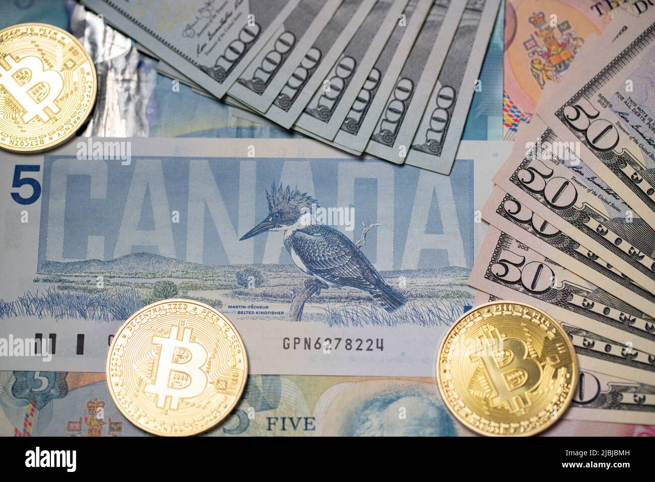 Toronto, Canada - Ottobre 30. 2021: Trading Crypto con US Dollar e Canadian Dollar. Monete in oro BTC su banconote in dollari dagli Stati Uniti d'America Foto Stock