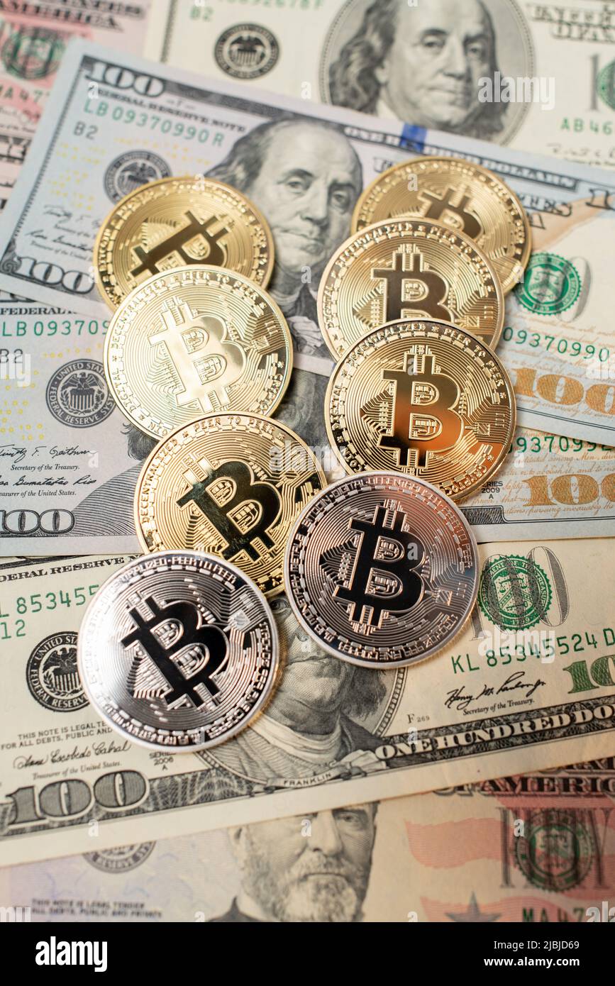Monete in Bitcoin d'oro e d'argento in cima a Dollar Bills. Centocinquanta banconote da dollari. Digital Money che lavora con la tecnologia della catena di blocchi Foto Stock