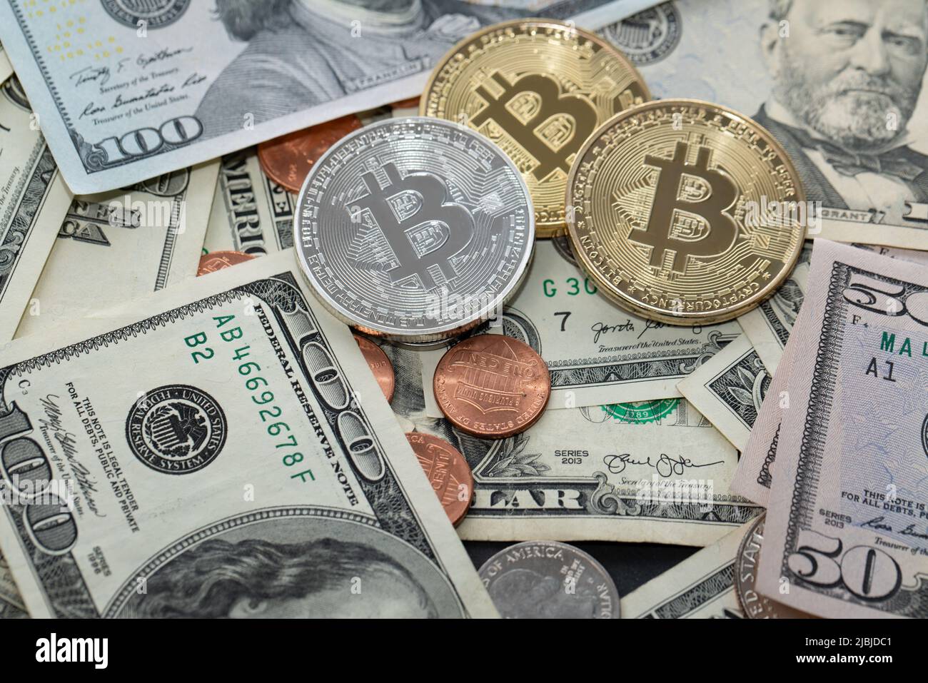 Monete in Bitcoin su banconote in dollari, banconote in cinquanta e cento dollari. Valuta USA e valuta criptata BTC Foto Stock