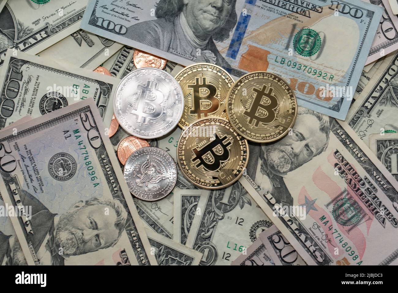 Monete in Bitcoin su banconote in dollari, banconote in cinquanta e cento dollari. Valuta USA e valuta BTC Crypto Foto Stock
