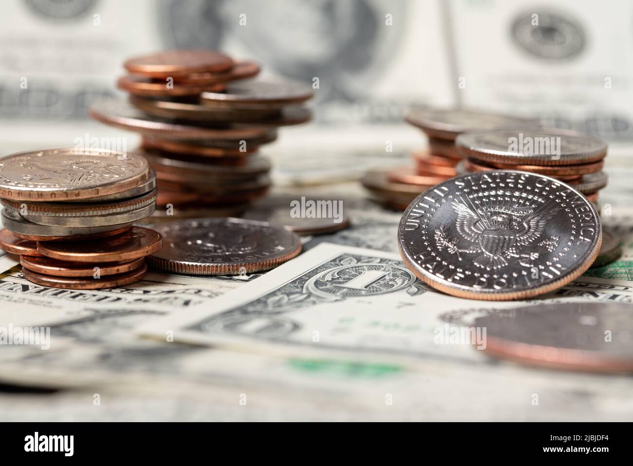 Accumulò monete in dollari sopra le banconote. Denaro e contanti dagli Stati Uniti. Concetto di mercato e di trading. Moneta da mezzo dollaro che riflette luce Foto Stock