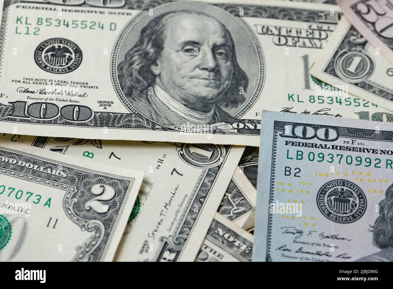 Banconote in dollari sparse. Banconote da un dollaro a cento dollari, rare due dollari tra un cumulo di contanti e l'altro. Sfondo con banconote in dollari statunitensi. Circa Foto Stock