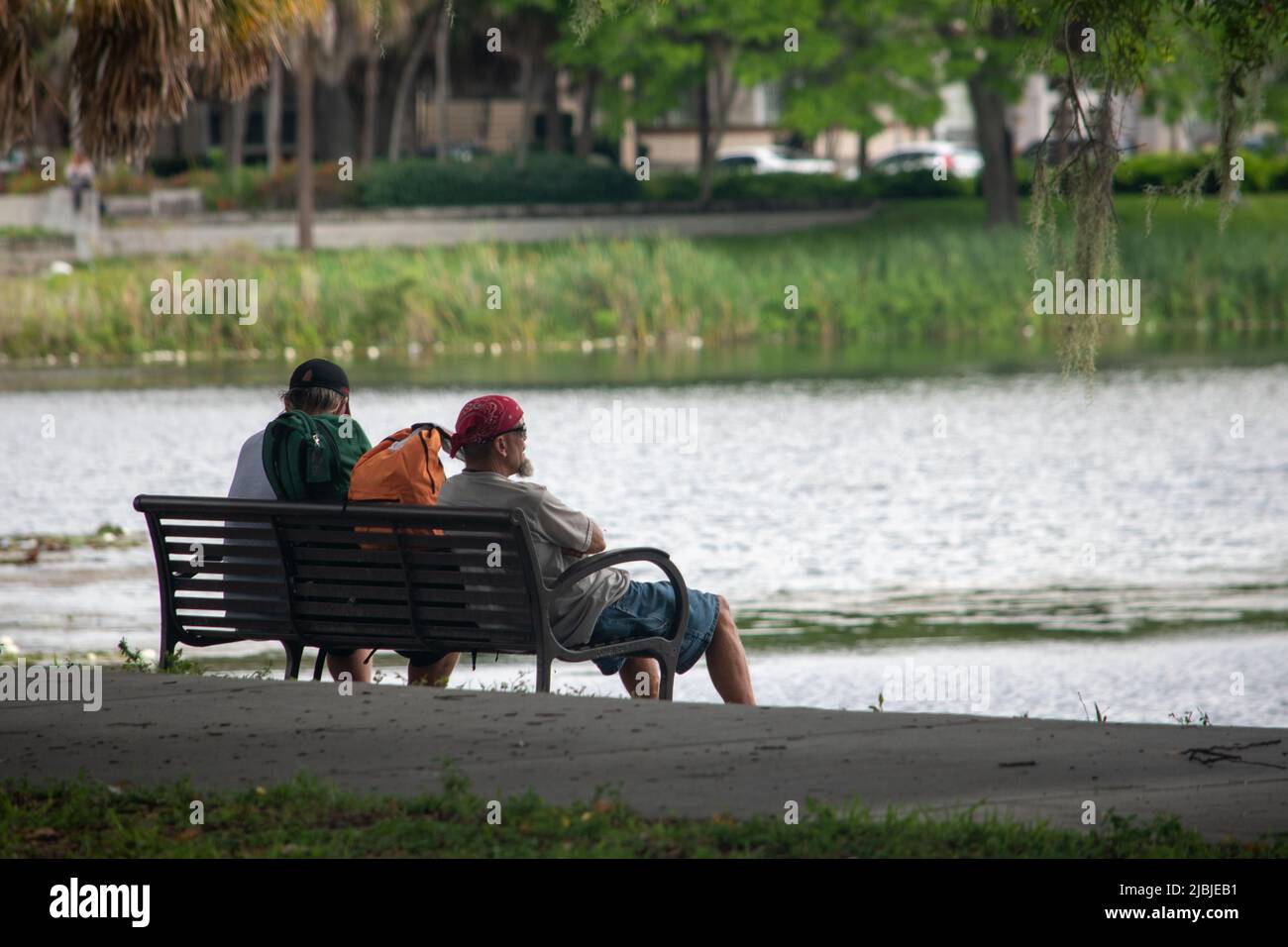 due vecchi amici sul banco del parco che guardano al lago Foto Stock