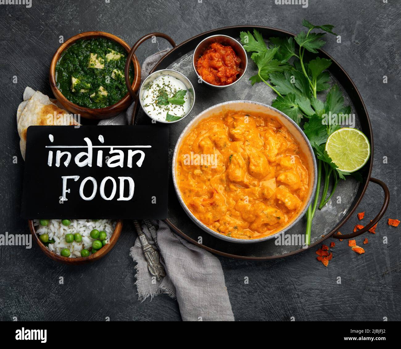 Curry indiano sul backgroound scuro. Concetto di cibo tradizionale. Piatti e stuzzichini della cucina. Vista piatta Foto Stock