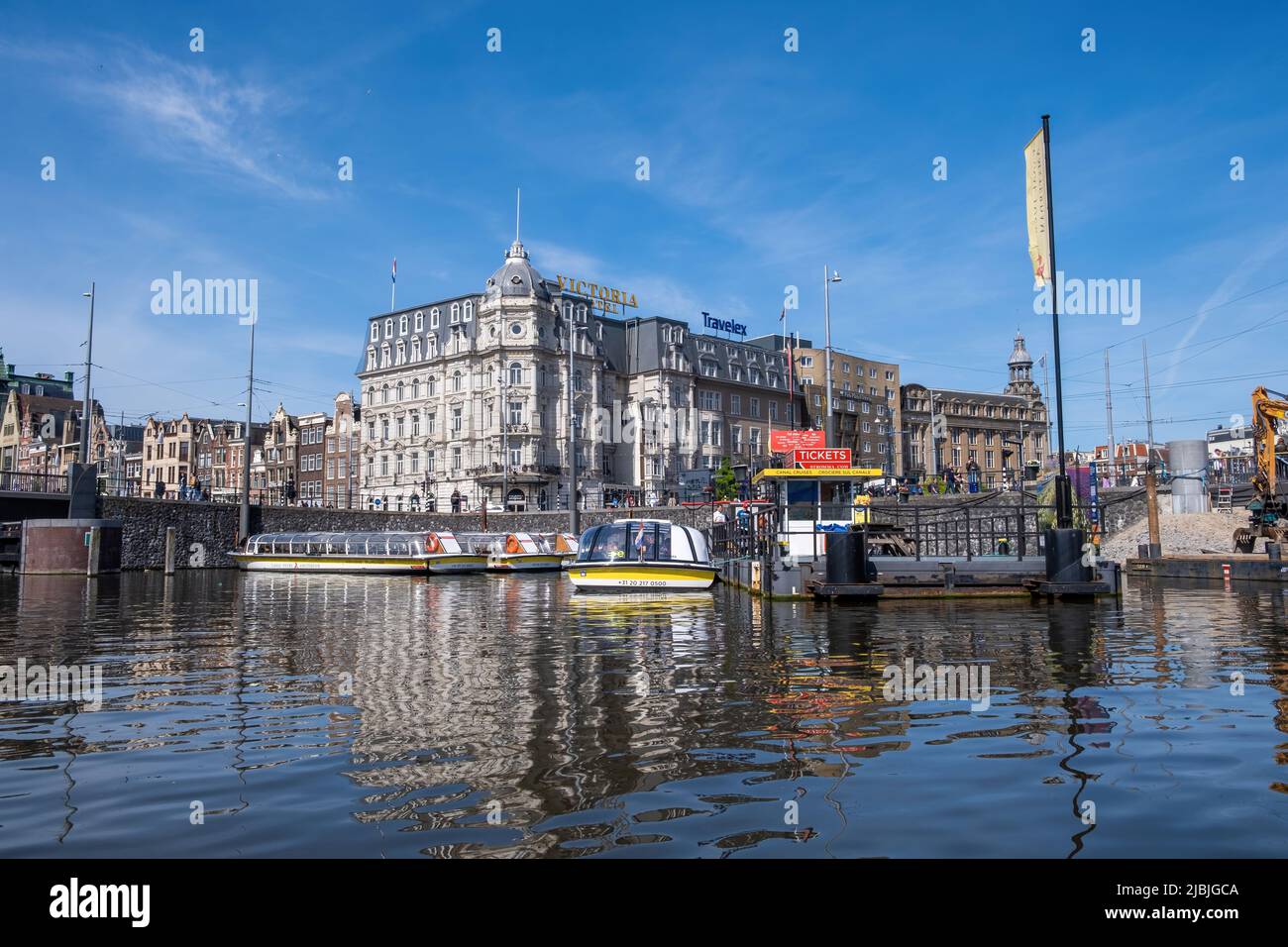 Amsterdam, Paesi Bassi 22 maggio 2022. Porto con barca da crociera sul canale ormeggiato per visitare l'Olanda. Edificio di architettura tradizionale, riflesso su w Foto Stock