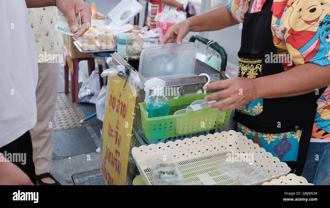 Denaro Cambio mani transazione in contanti Sukhumvit Road Bangkok Thailandia Foto Stock