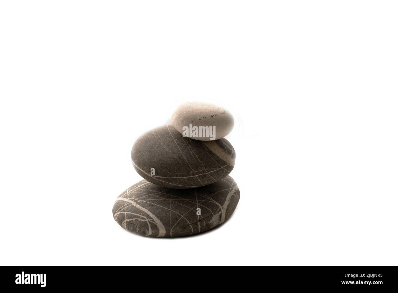 Una pila di pietre su uno sfondo bianco isolato .equilibrio e armonia. Copia foto spazio.orizzontale. Concetto di spa e assistenza sanitaria. Foto Stock