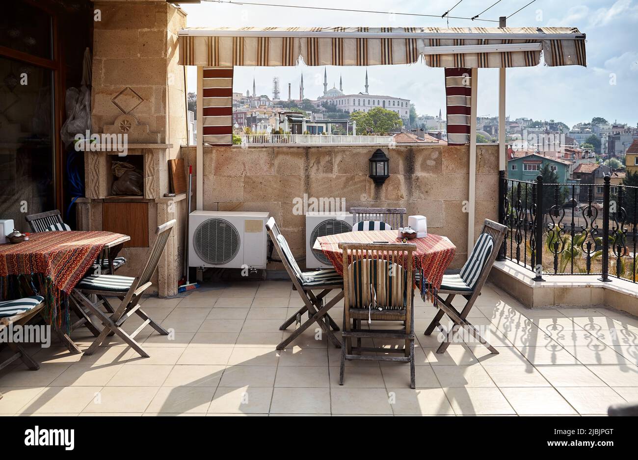 Ristorante caffetteria sul tetto dell'hotel con tavolo e sedie. Vista della famosa moschea di Ayasofya a Istanbul, Turchia Foto Stock