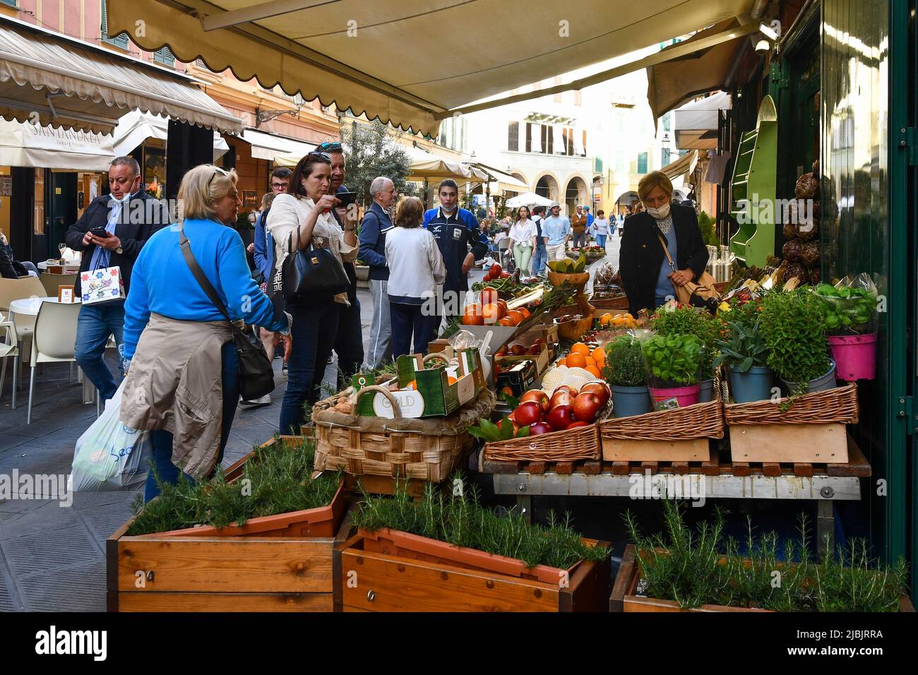 Frutta, verdura ed erbe aromatiche sono esposte a fianco di un negozio di alimentari in una strada affollata del vecchio villaggio di pescatori, Santa Margherita Ligure, Genova Foto Stock