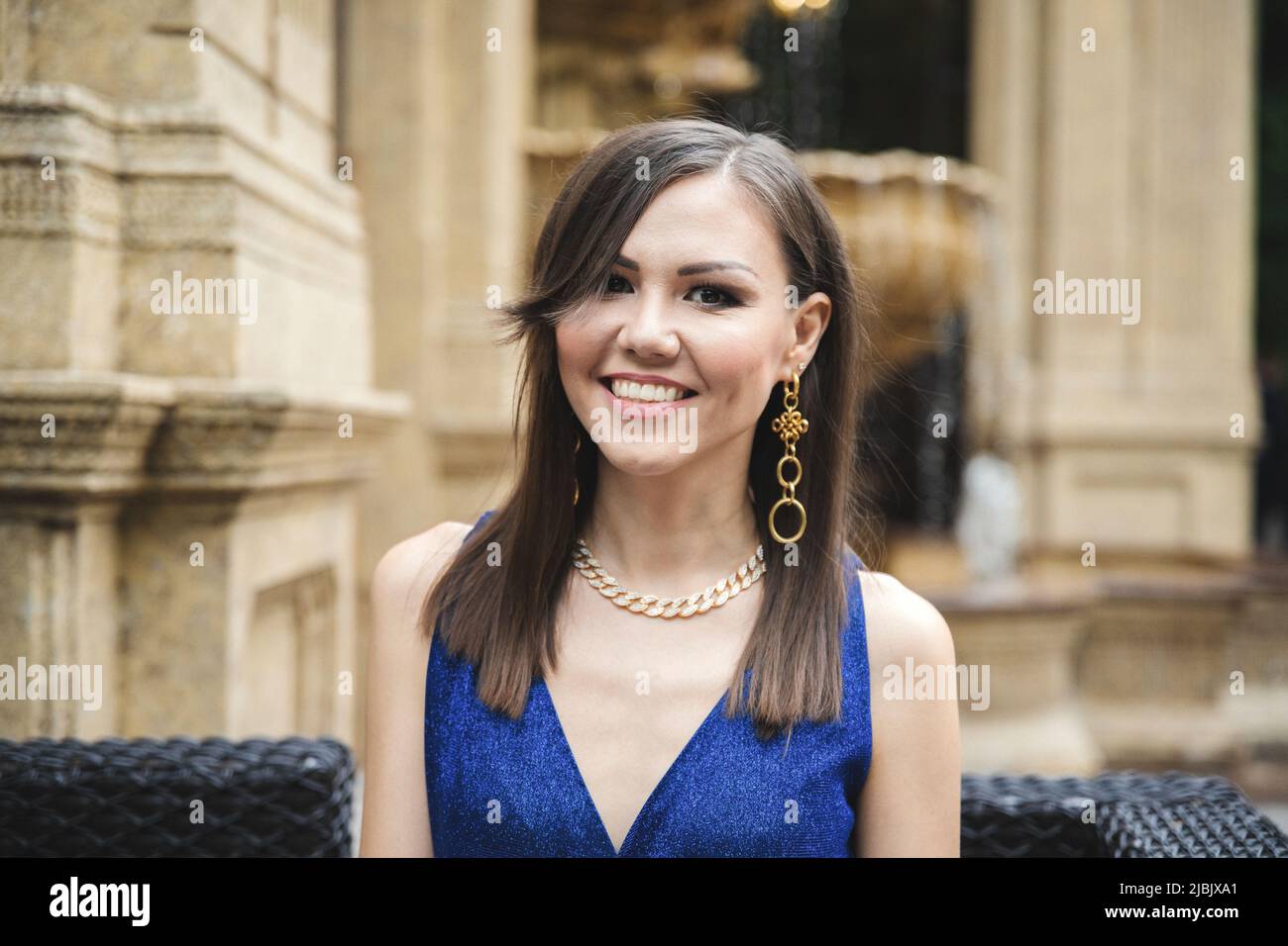 Multirazziale bella sorridente donna in abito blu ritratto esterno Foto Stock